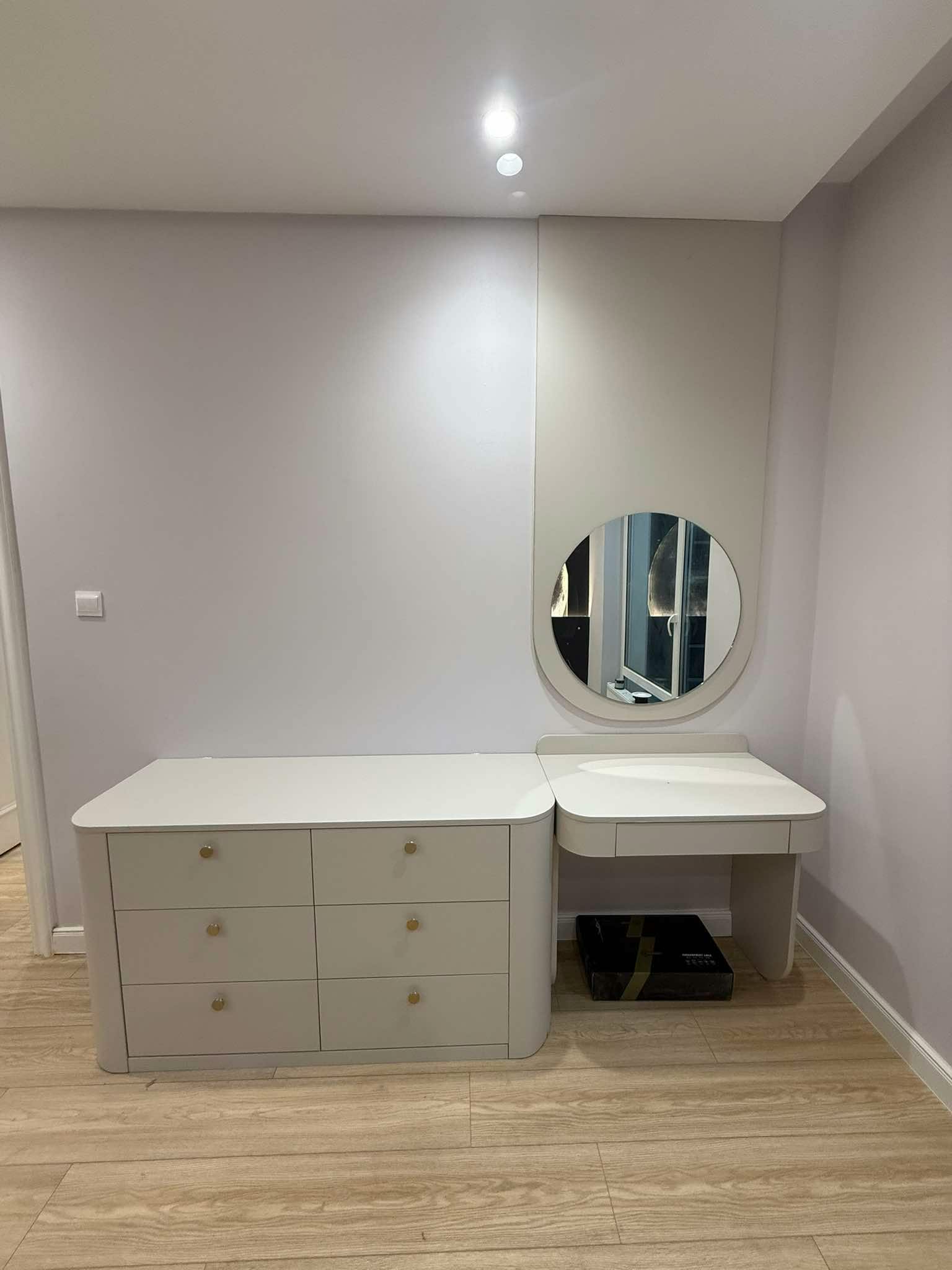Dresser with round mirror and soft grey tones
