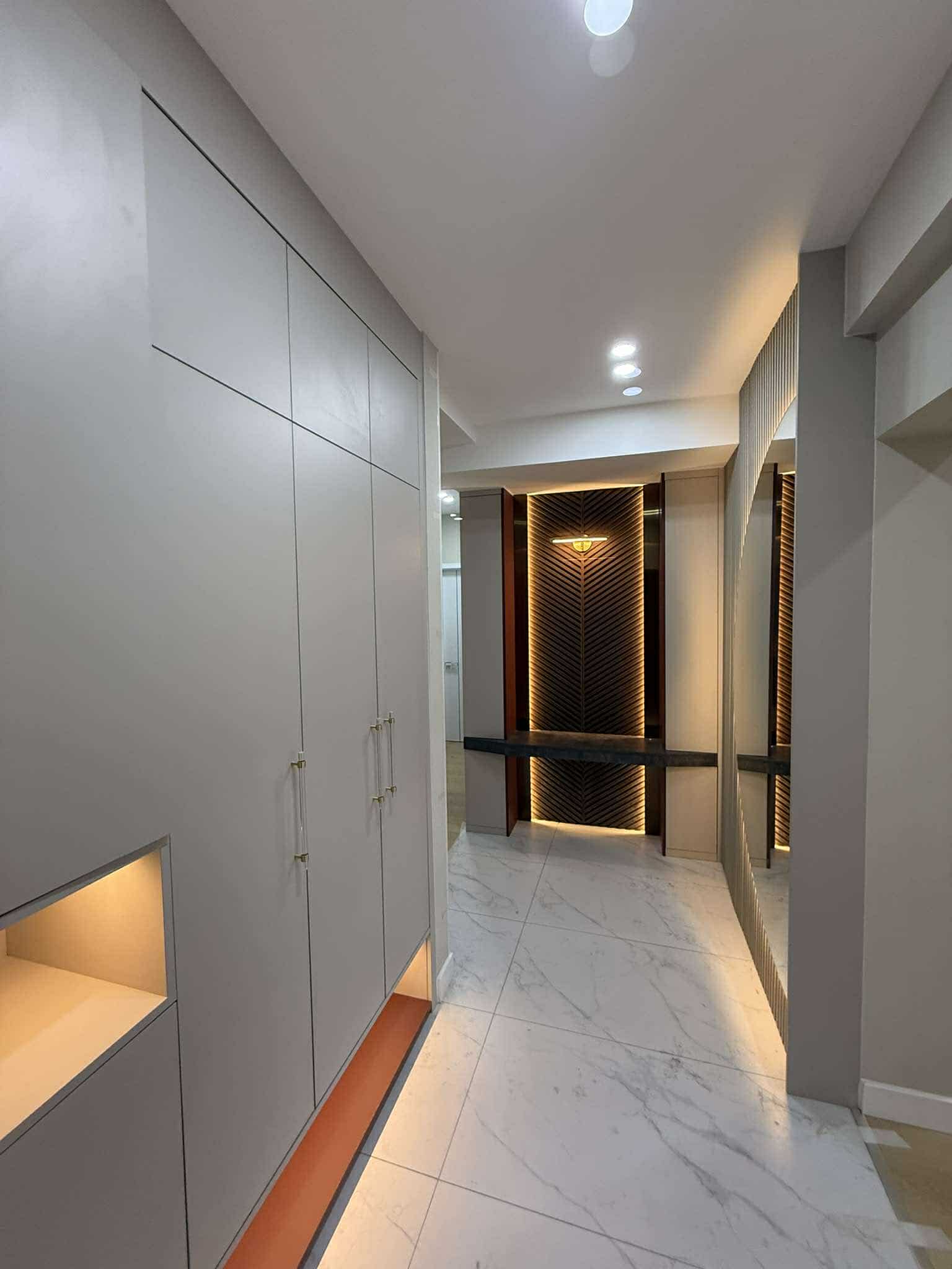 Marble-floored corridor with full-height grey cabinets