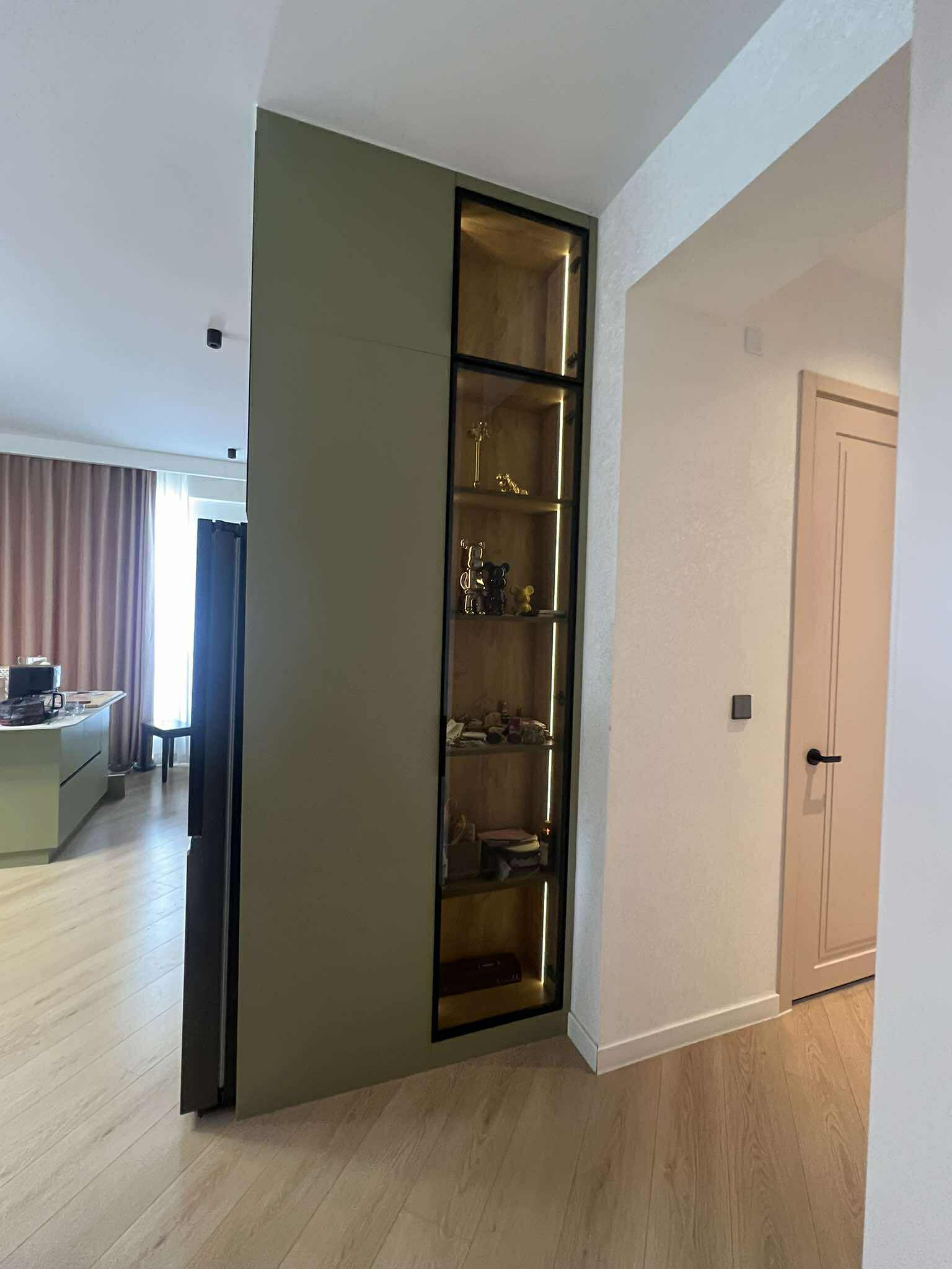Olive green accent wall with lit display cabinet