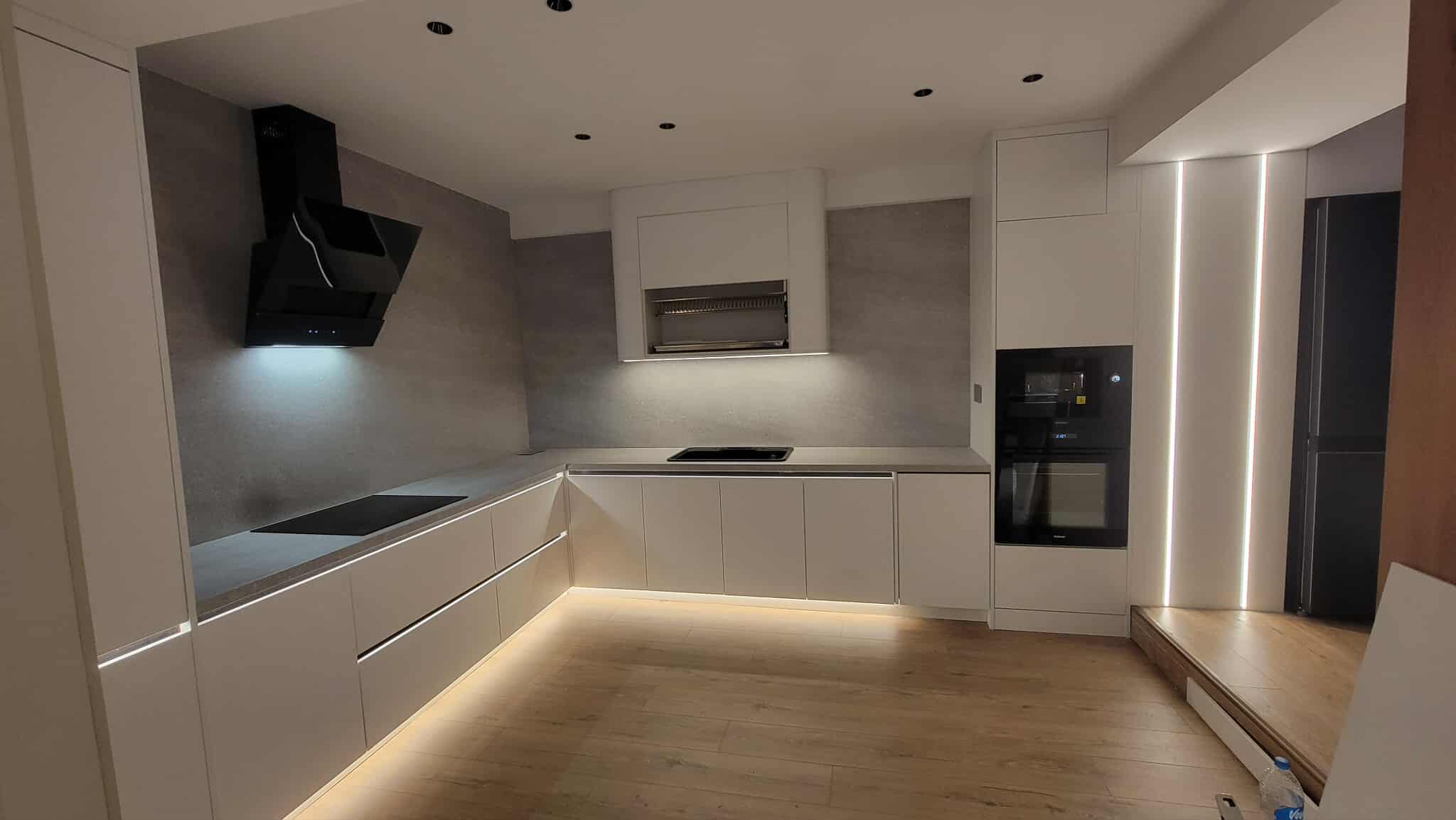 U-shaped white kitchen with under-cabinet LED glow
