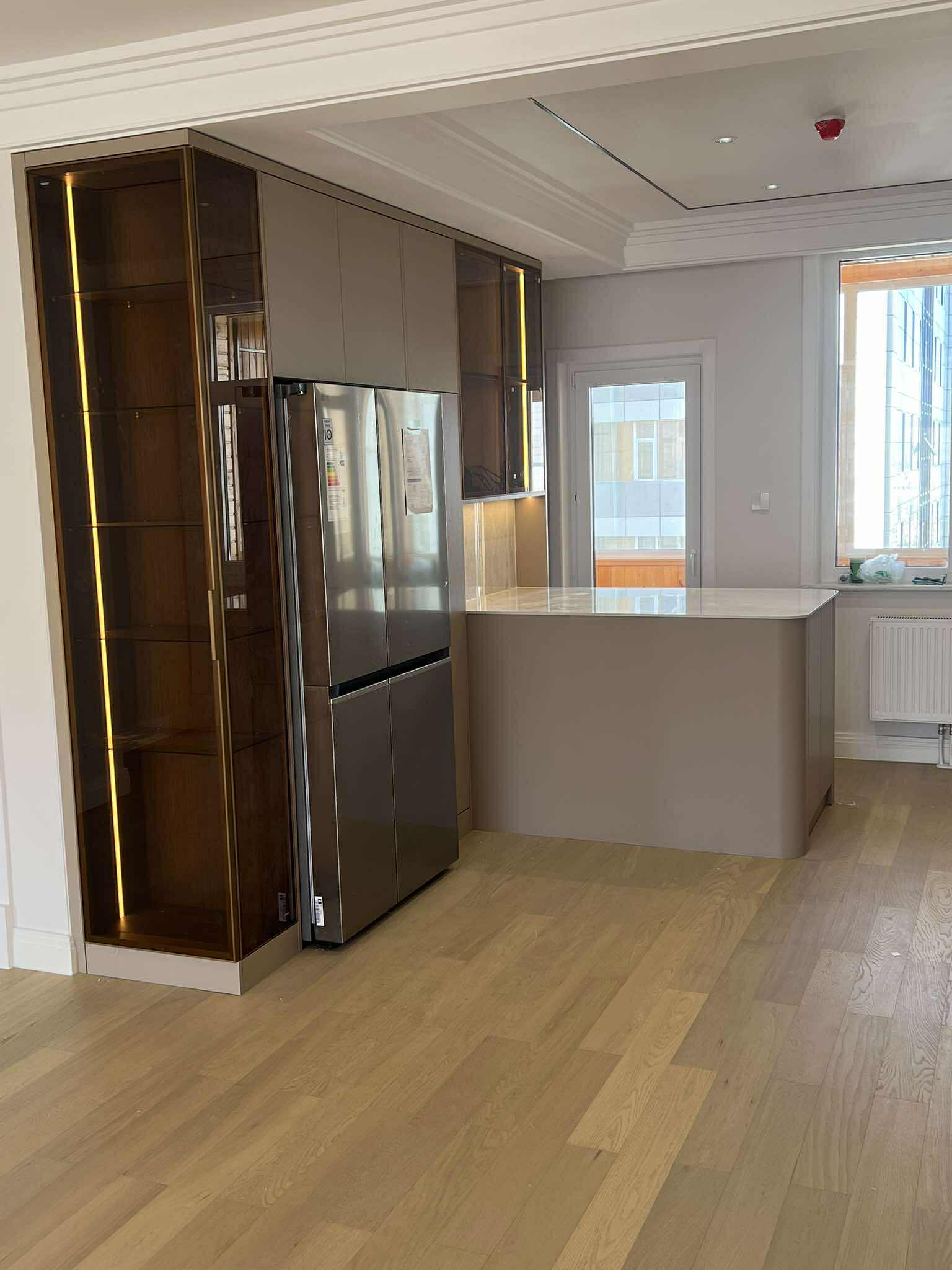 Kitchen with bronze glass display cabinet and steel fridge