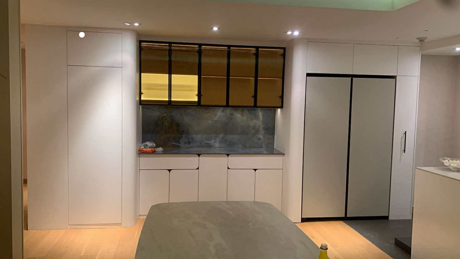 Kitchen with bronze glass upper cabinets and island