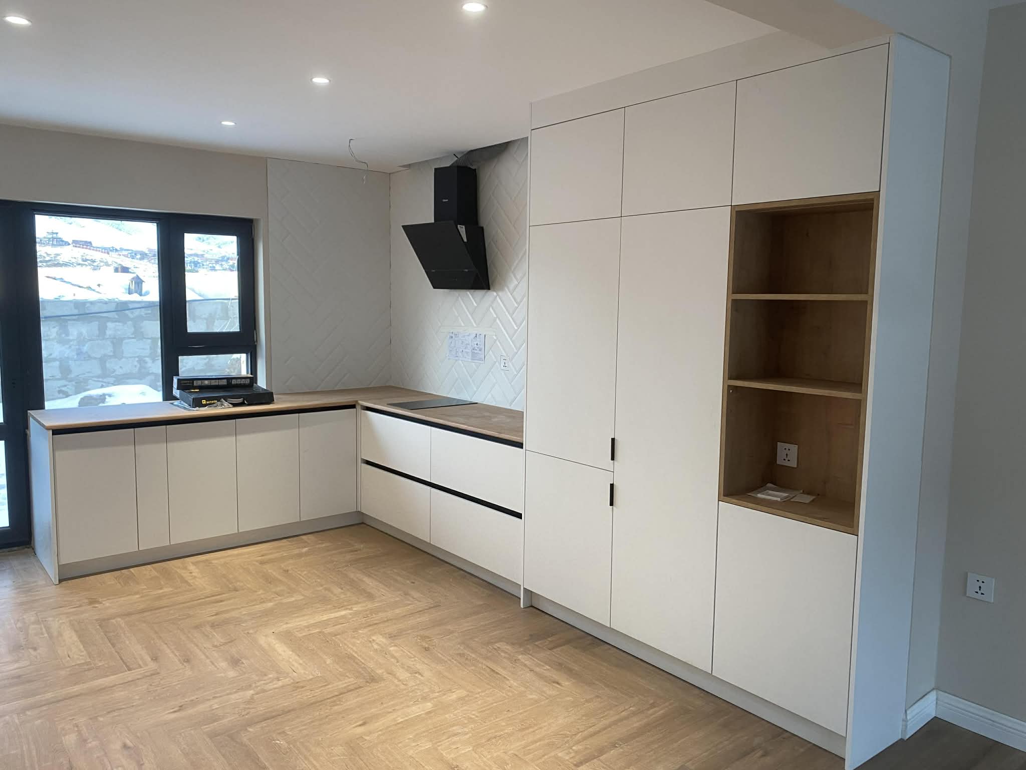 Cream kitchen with oak shelving and herringbone floor