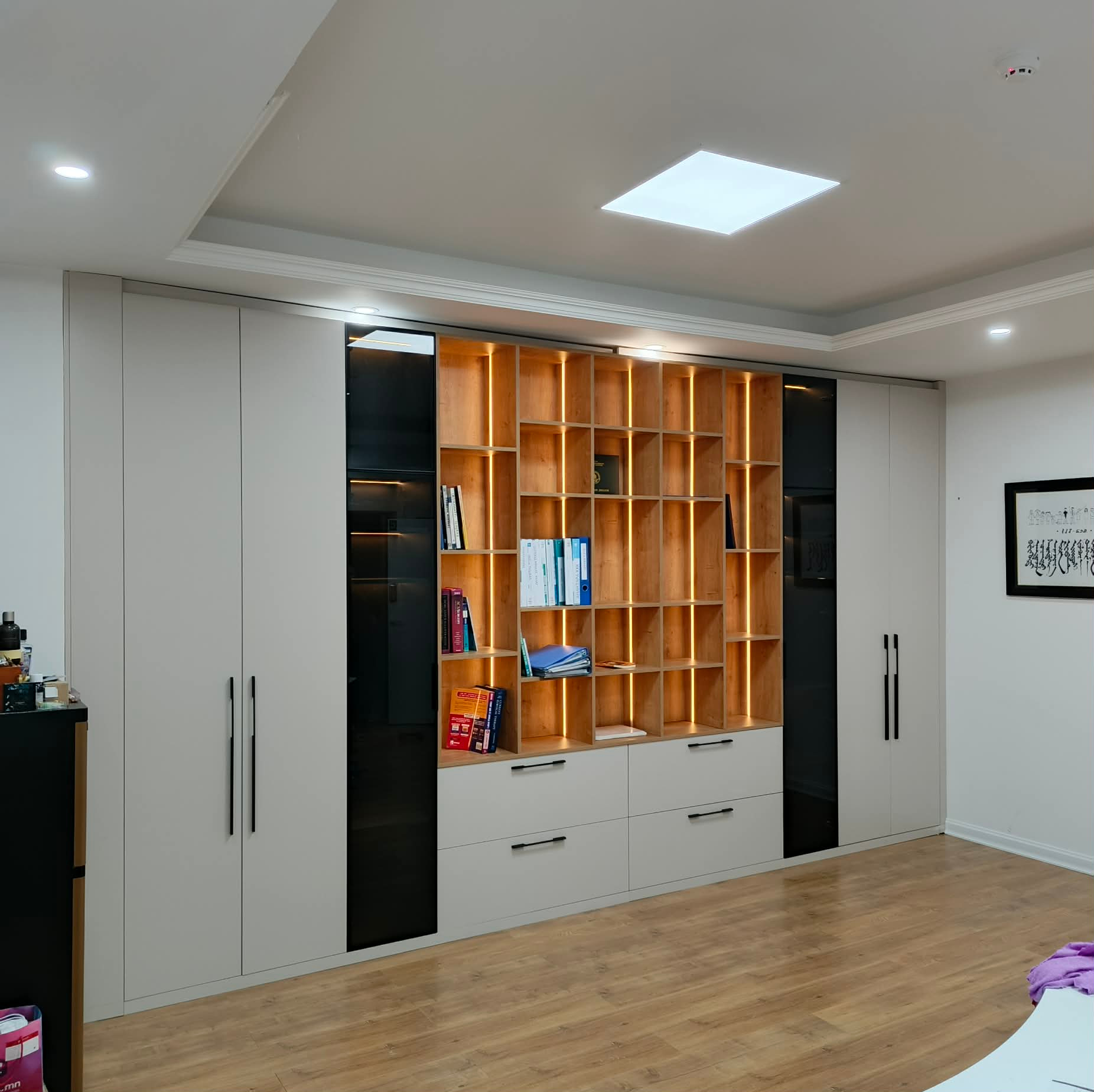Living room with floor-to-ceiling bookcase and warm amber lighting