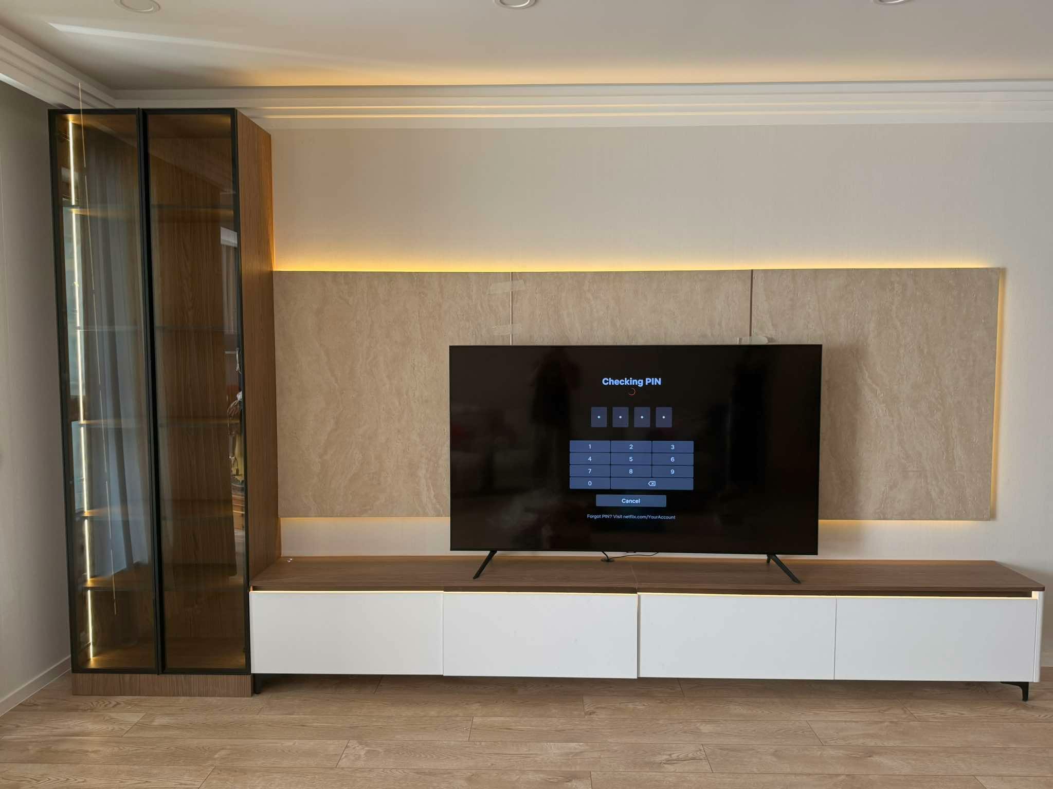 TV wall with wood panel backdrop and backlit display