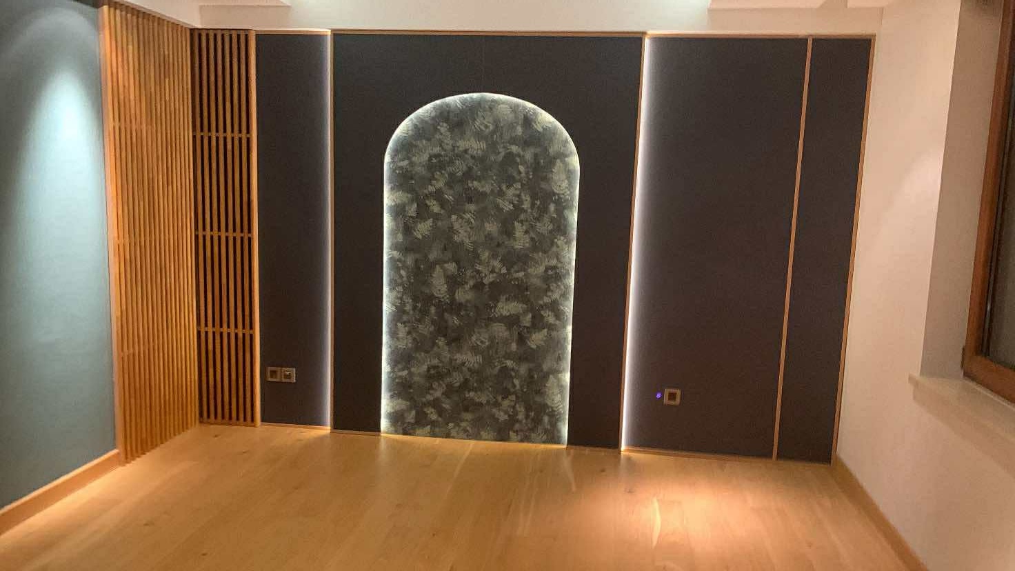 Dark arched feature wall with slatted wood panels